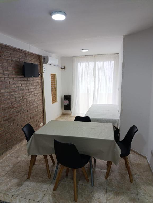 a room with a table and chairs and a bed at Dpto Centro de Carlos Paz - Avellana in Villa Carlos Paz