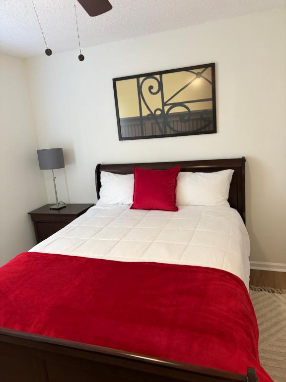 ein Schlafzimmer mit einem großen Bett mit einer roten Decke in der Unterkunft Home away from home in Atlanta
