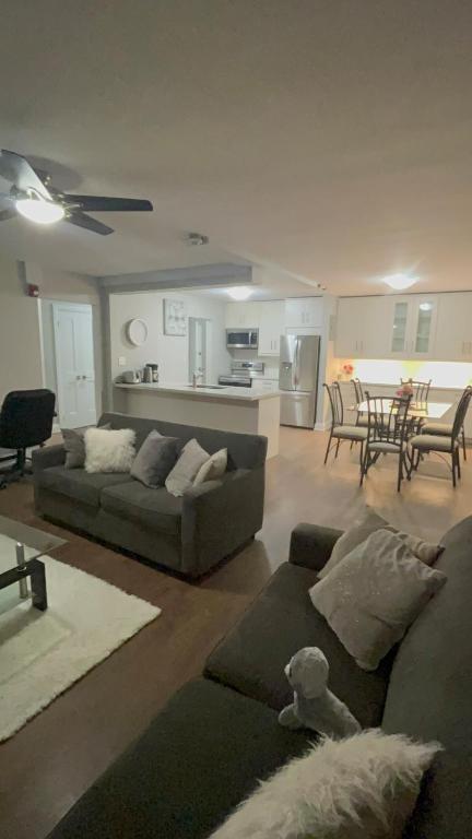 a living room with two couches and a kitchen at Luxurious Two Bedroom Apartment in Burlington