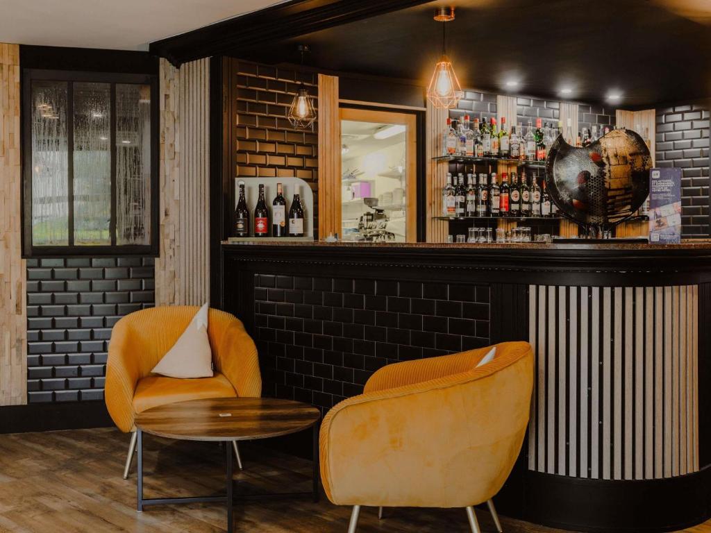 a bar with two chairs and a table at Mercure Annecy Sud in Annecy