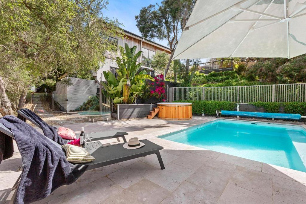 Bird House Wellness Retreat - Sauna Mineral Pool في راي: مسبح وكرسي ومظلة بجواره