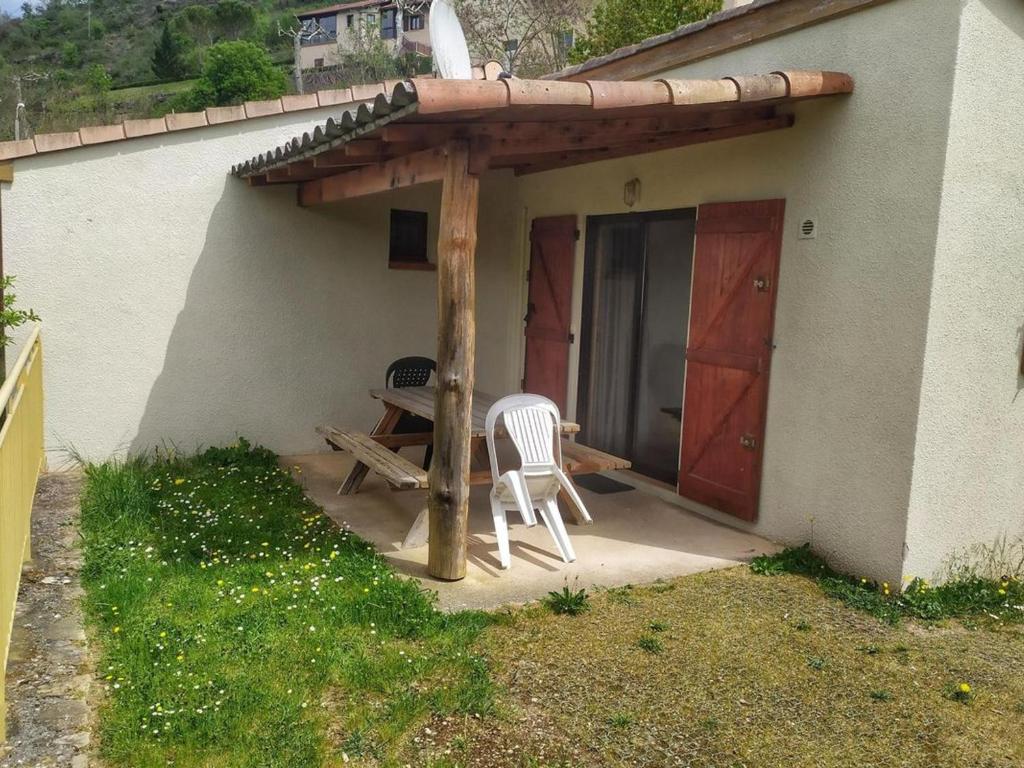 a patio with two chairs and a wooden pergola at Chalet confortable avec terrasse - 4 personnes - API-1-52-908 in Saint-Rome-de-Tarn