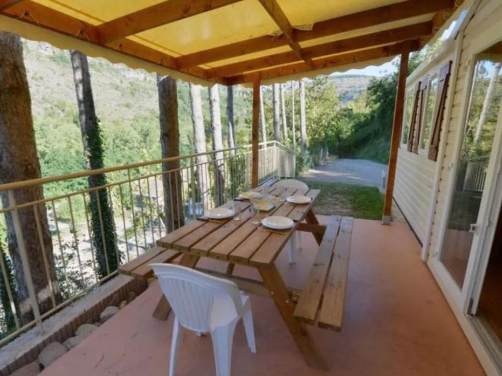 a porch with a wooden table and chairs on it at Mobil home avec Terrasse - 3 Chambres, 6 Personnes - API-1-52-896 in Saint-Rome-de-Tarn