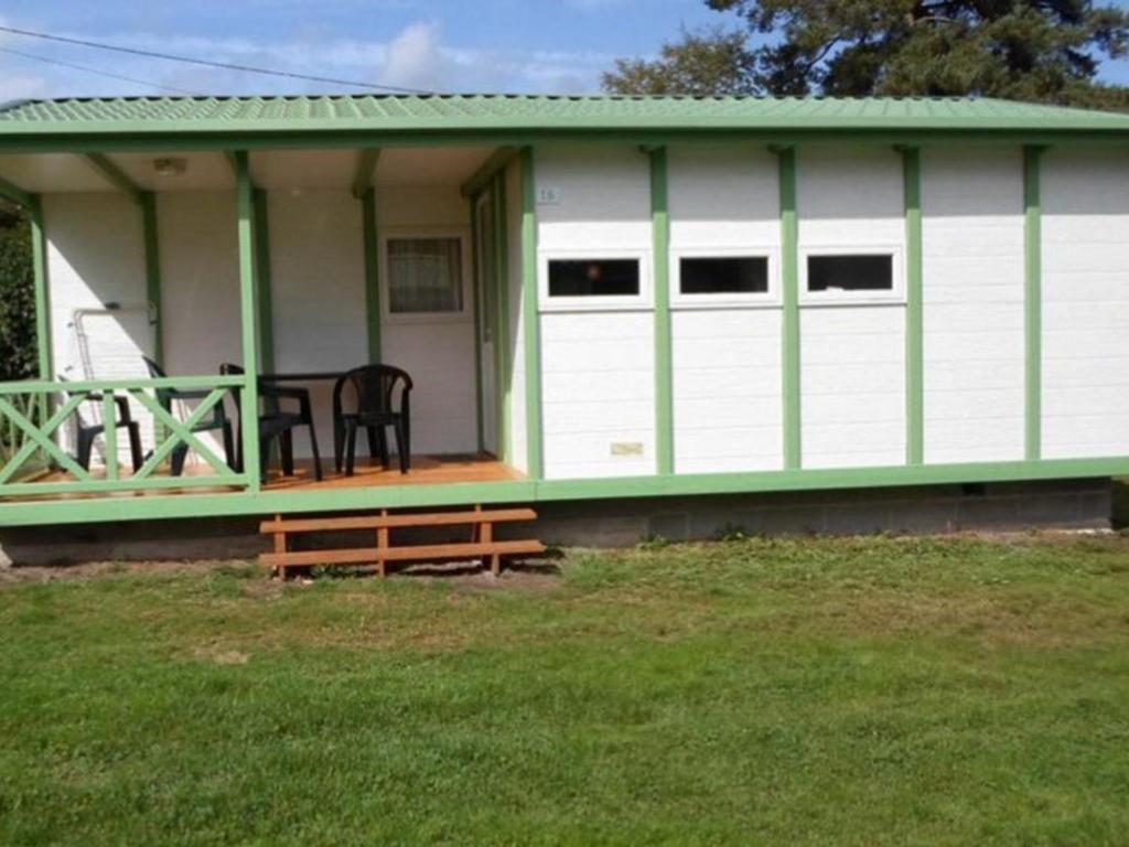 a green and white shed with a table on the porch at Chalet 32m² avec Terrasse - 2 Chambres - API-1-52-939 in La Chapelle
