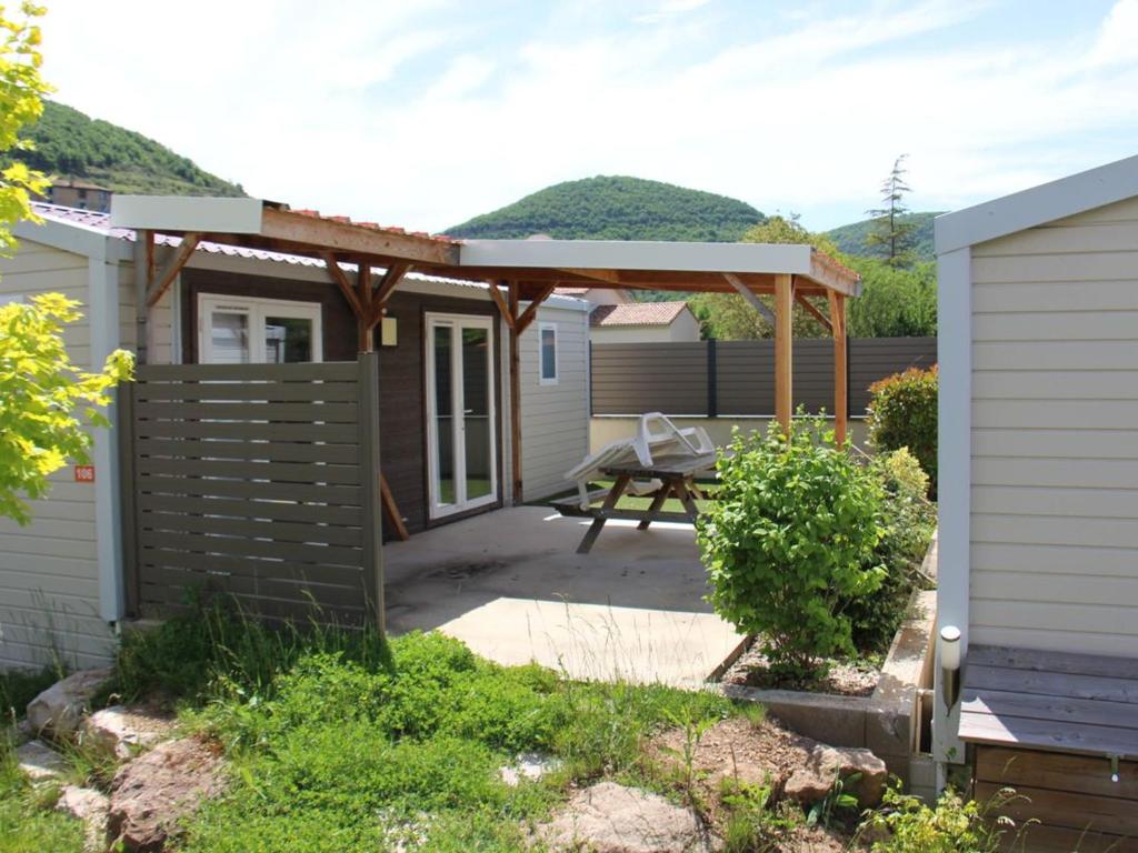 a patio with a picnic table and a pergola at Mobil-home confortable avec terrasse pour 5 personnes - API-1-52-916 in Saint-Rome-de-Tarn
