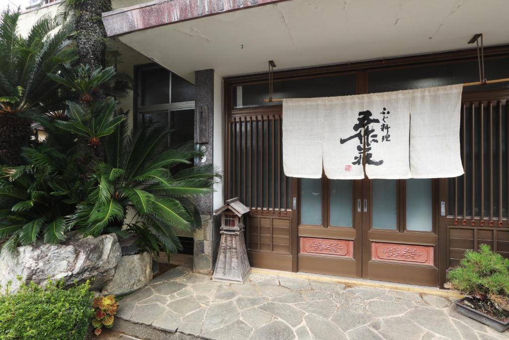 a front door of a building with a sign on it at 五作荘 in Mihama
