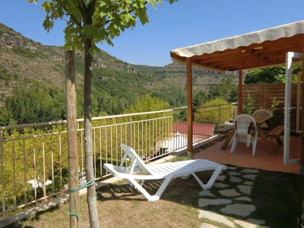 a patio with a white chair and a pergola at Mobil home 28m² à Saint-Rome-de-Tarn - Terrasse - API-1-52-943 in Saint-Rome-de-Tarn