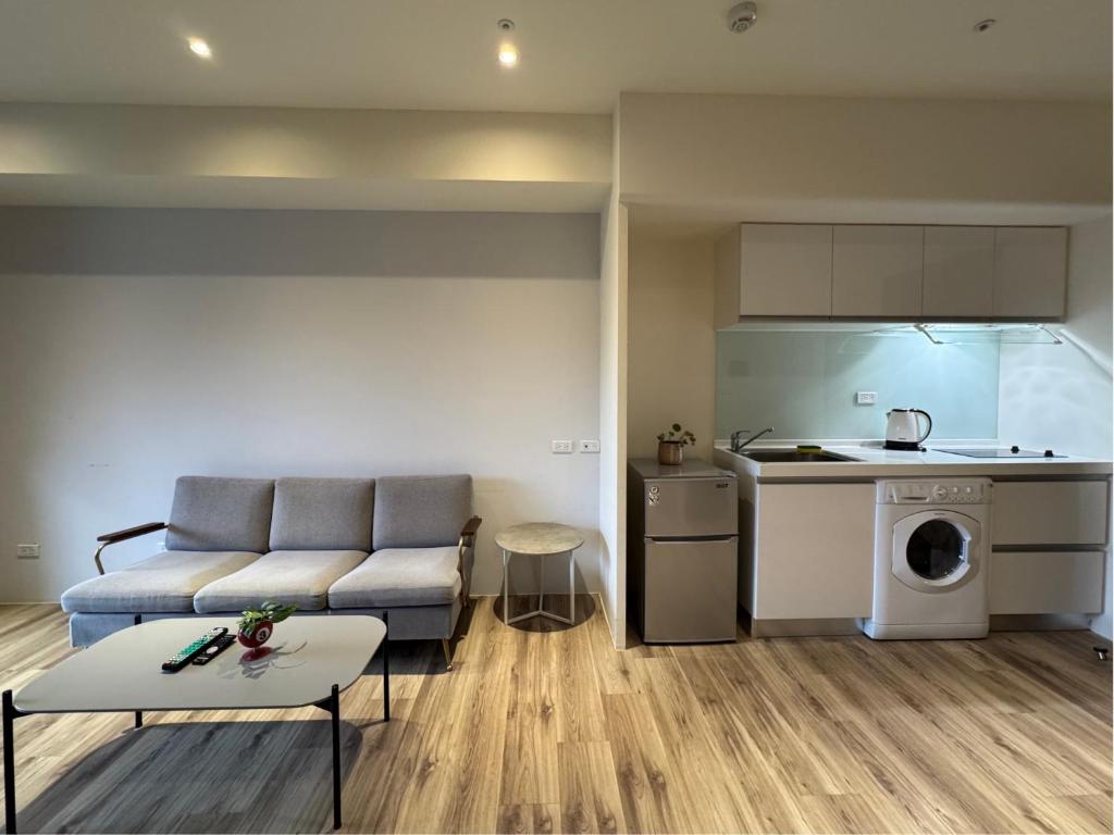 Una sala de estar con un sofá y una cocina. en Toucheng Joyful 宜蘭海景民宿-頭城小確幸 寵物友善 電動車充電, en Toucheng