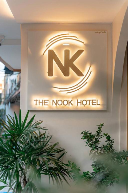 a sign for the nook hotel on a wall with plants at The Nook Hotel in Chiang Mai