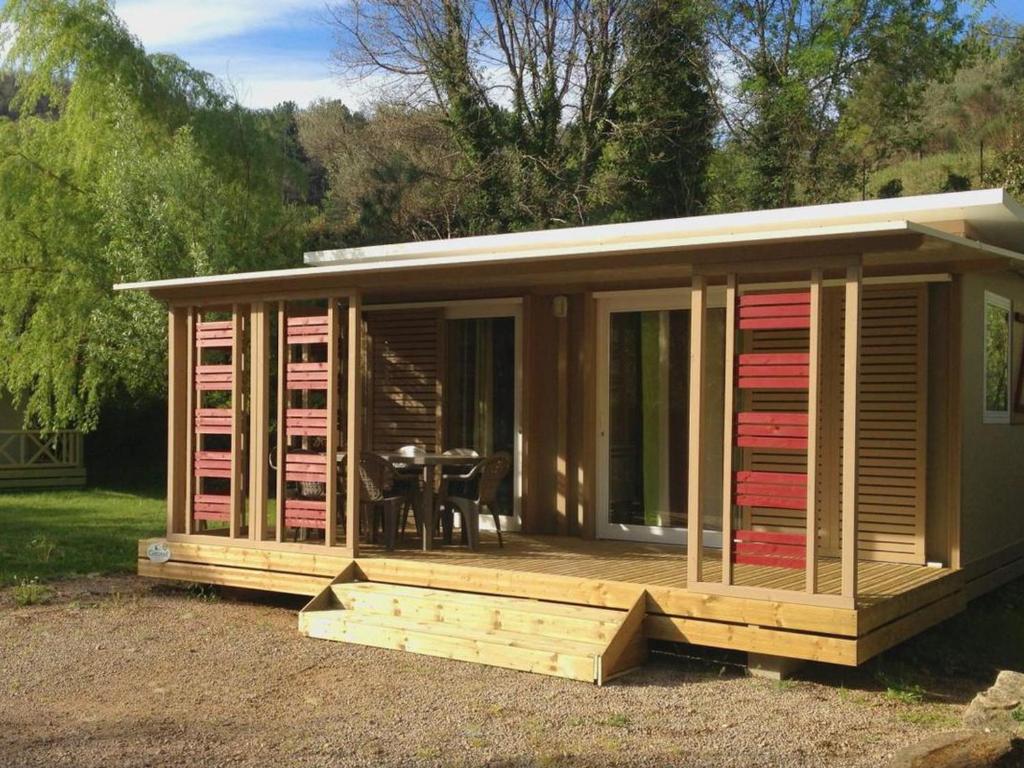 Chalet avec Terrasse à Soubès - Accès Handicapé - API-1-52-955 في Soubès: منزل خشبي كبير يحتوي على طاولة بداخله