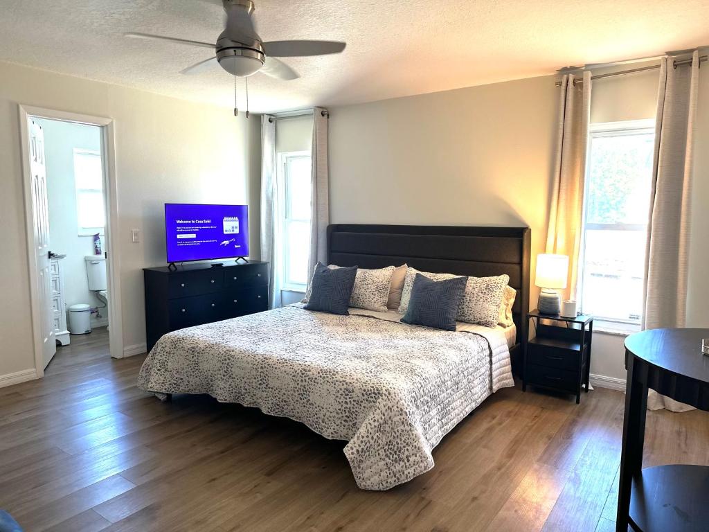 a bedroom with a bed and a flat screen tv at CASA SOLÉ, South Tampa in Tampa