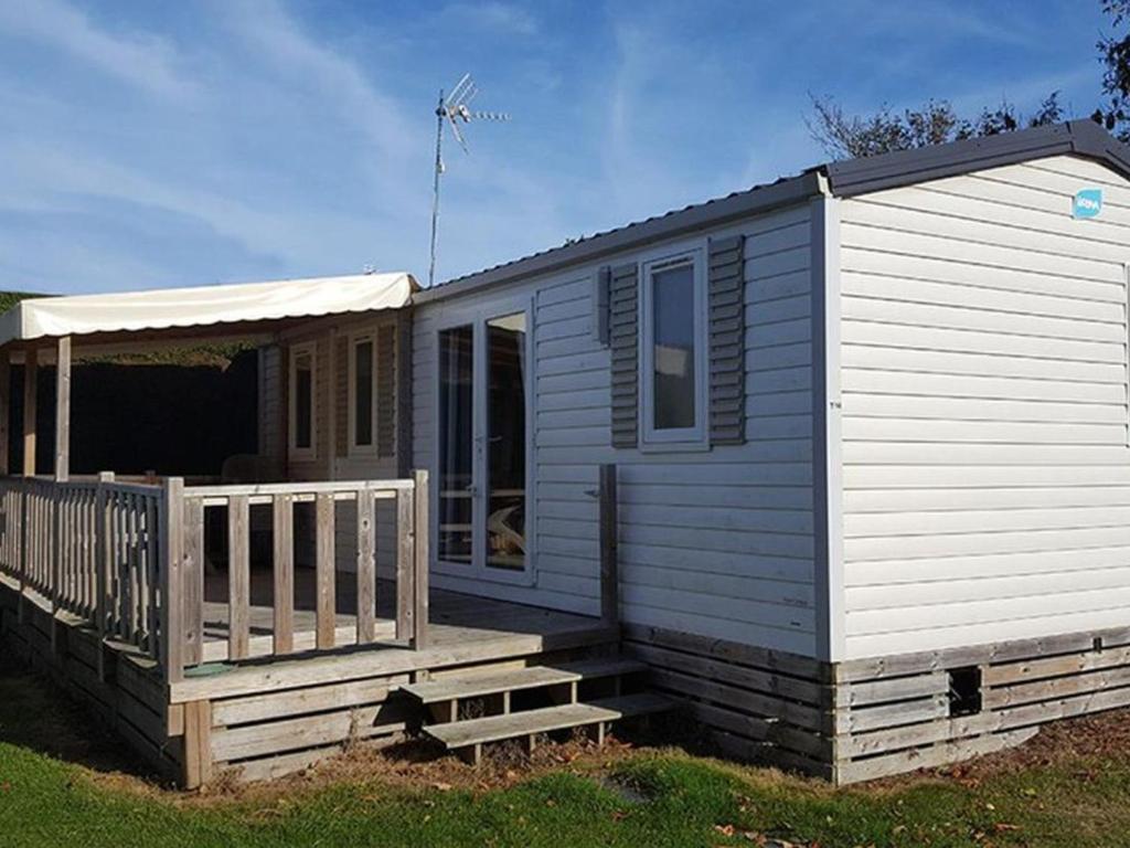 ein kleines Haus mit einer Veranda und einer Terrasse in der Unterkunft Mobil home confortable avec terrasse - API-1-52-1015 in Port Blanc