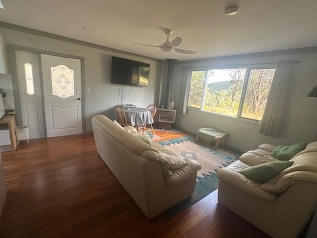 a living room with two couches and a table at Quiet Rural Retreat - Kimbriki in Mount George