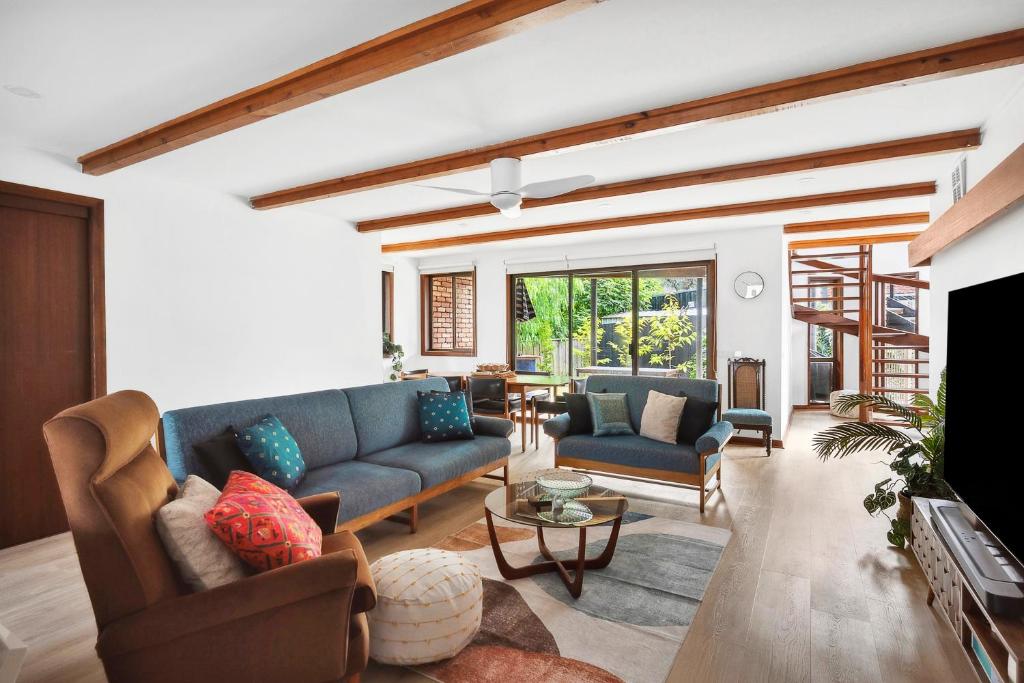 a living room with blue couches and a fireplace at Clifton Retreat large family home new renovation in Clifton Springs