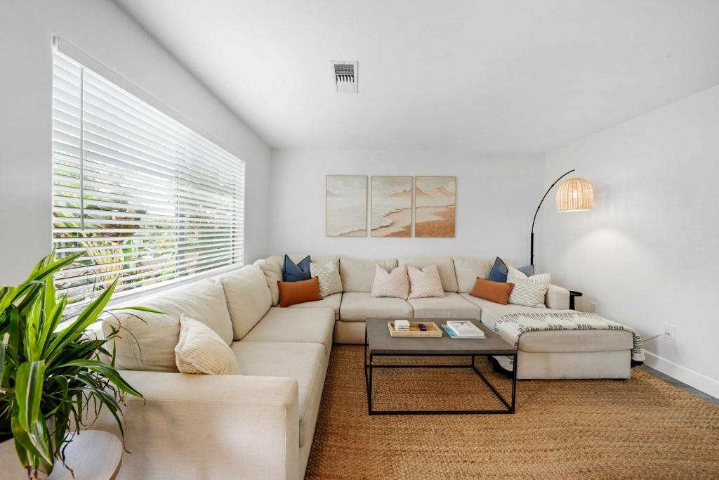 Leucadia's Beach House w Game Room في إنسينيتاس: غرفة معيشة بيضاء مع أريكة وطاولة