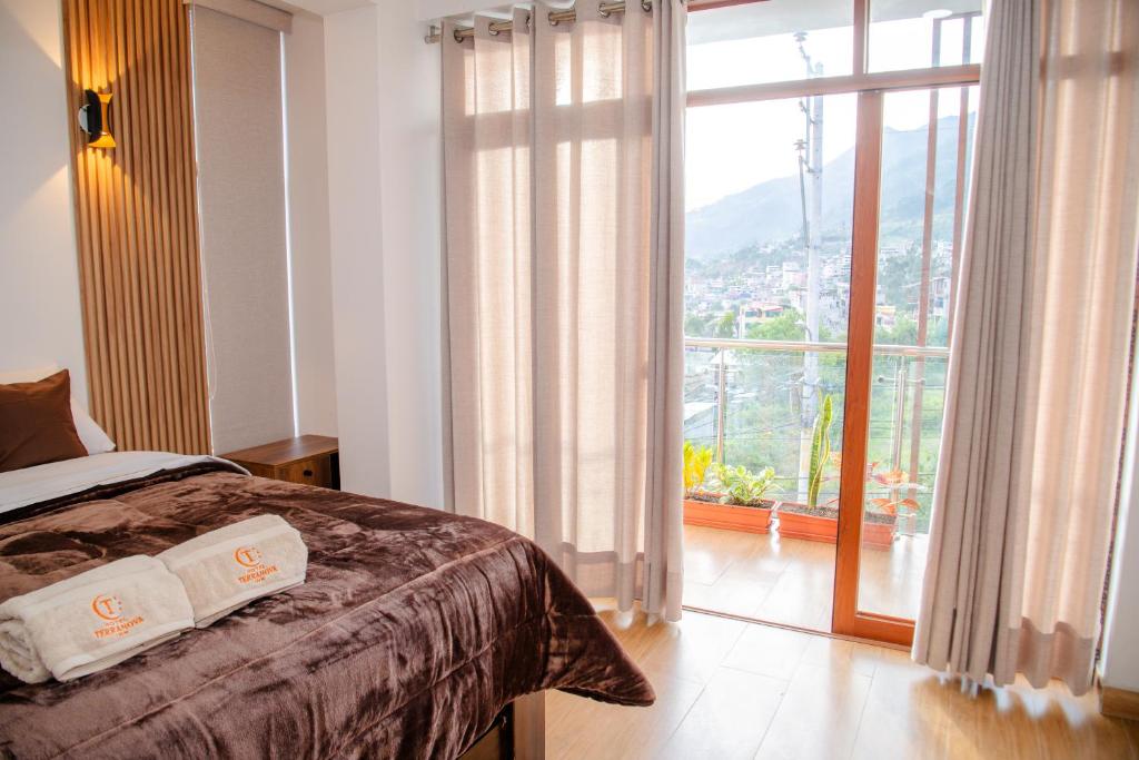 a bedroom with a bed and a large window at HOTEL TERRANOVA Abancay in Abancay