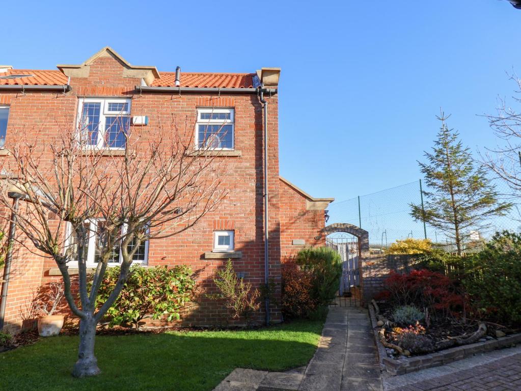 a brick house with a garden in front of it at Pond Farm View in Saltburn-by-the-Sea