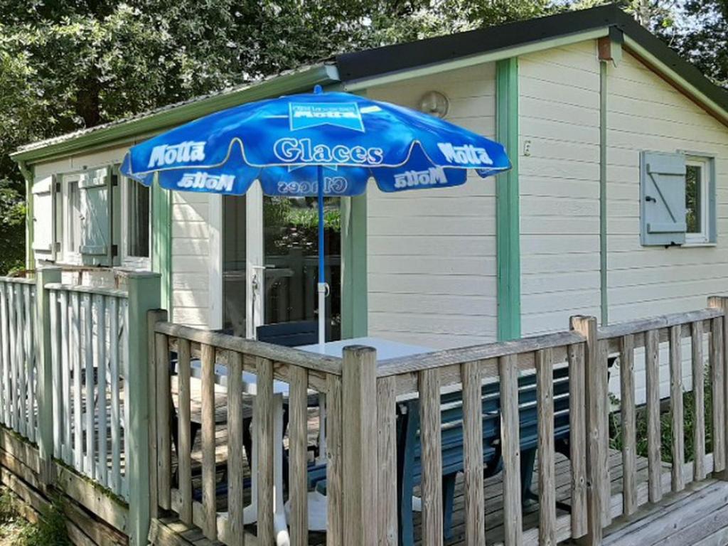 a small house with a blue umbrella on a porch at Chalet de 28m² pour 4 personnes avec terrasse - API-1-52-1035 in Garindein