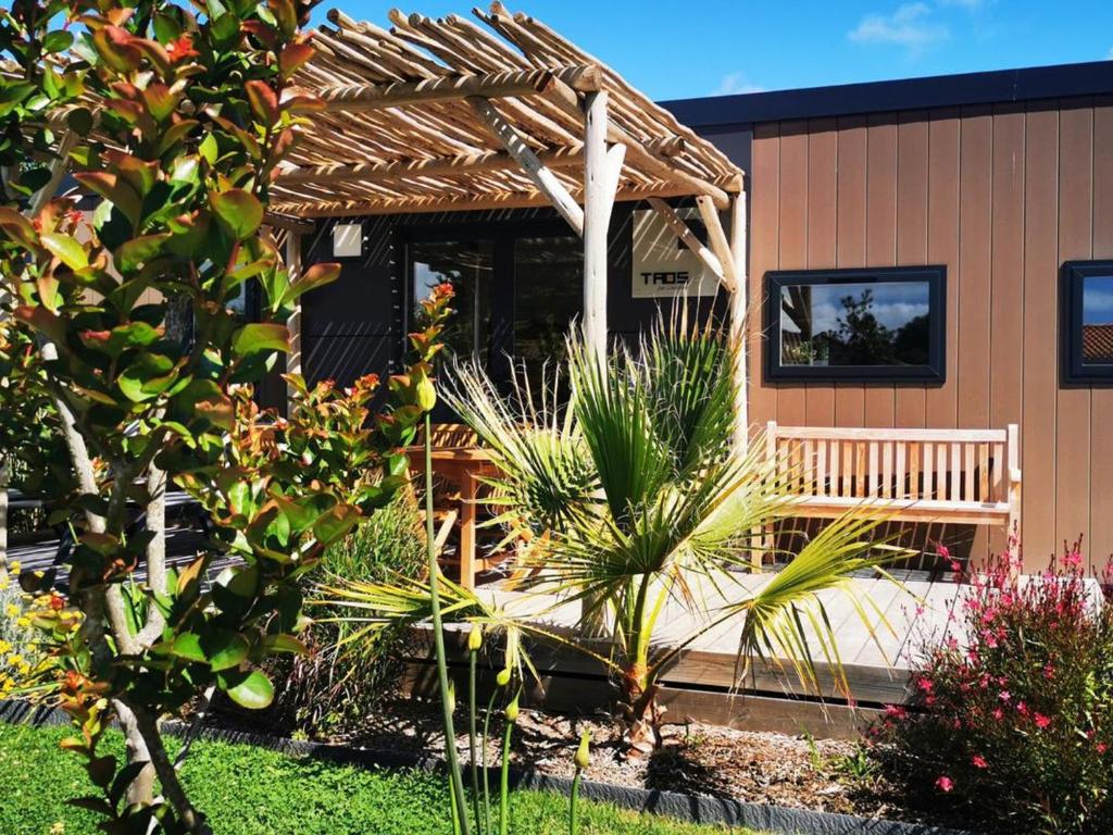 ein Haus mit einer Bank davor in der Unterkunft Mobil Home Prestige avec Terrasse à Saint-Jean-de-Monts - API-1-52-1055 in Notre-Dame-de-Monts