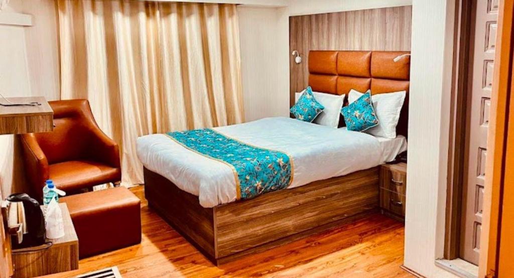 a bedroom with a bed and a chair at MGallery Hotel in Srinagar