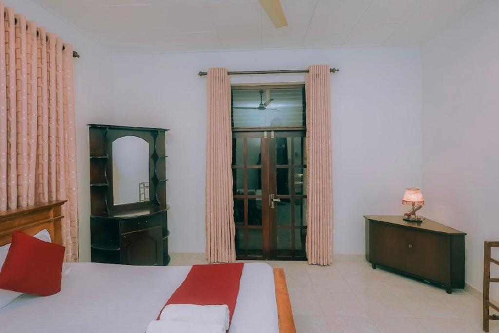 Un dormitorio con una cama, una cómoda y un espejo. en Hamilton View, en Negombo