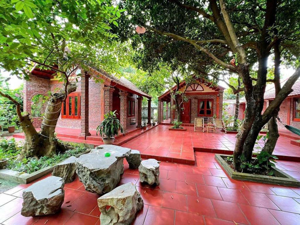 Un patio con rocas y árboles y un edificio. en TAM FAMILY HOMESTAY and RESTAURANT, en Ninh Binh