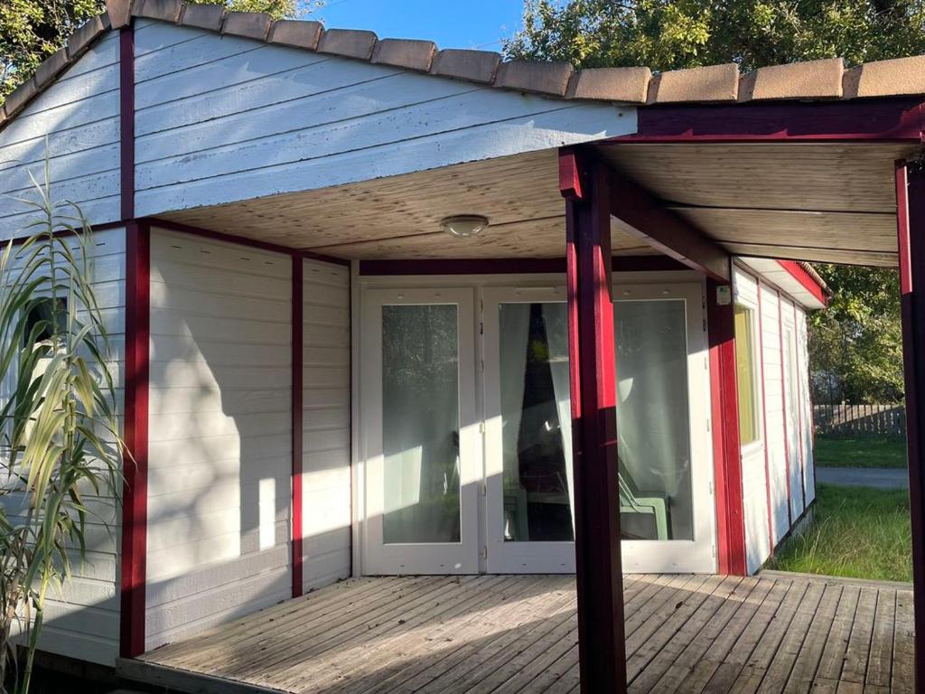 ein kleines Haus mit einer großen Tür auf einer Terrasse in der Unterkunft Chalet à Saint-Pierre-d'Oléron avec Terrasse - API-1-52-1111 in Dolus d'Oléron