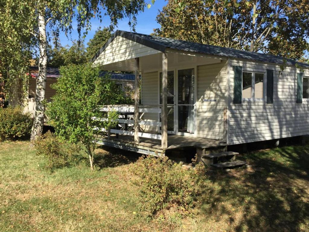 una piccola casa bianca con un portico in cortile di Mobil home confortable avec terrasse - API-1-52-1115 a Luynes