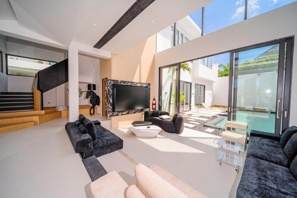 a living room with a tv and a pool at Bangtao New Luxury 7 Bedrooms Modern Space Aesthetic Design Private Pool Villa Private Movie Theater in Ban Nong Chaeng