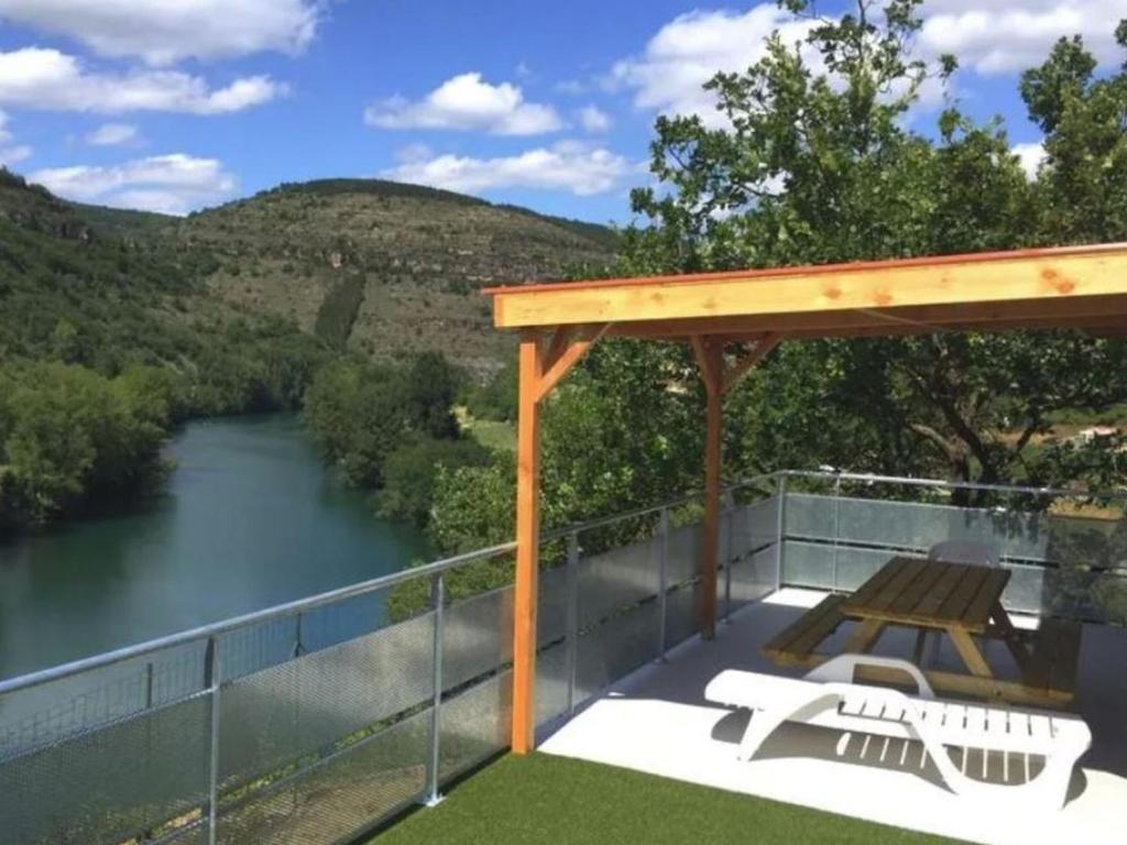 a deck with a view of a river at Mobil home 32m² avec terrasse au Camping De La Cascade, 3 chambres pour 6 personnes - API-1-52-1162 in Saint-Rome-de-Tarn