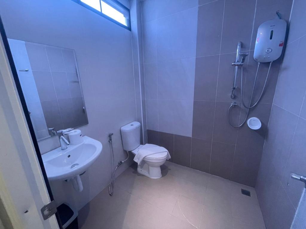 A compact tiled bathroom with a walk-in shower, toilet and wall-mounted water heater.
