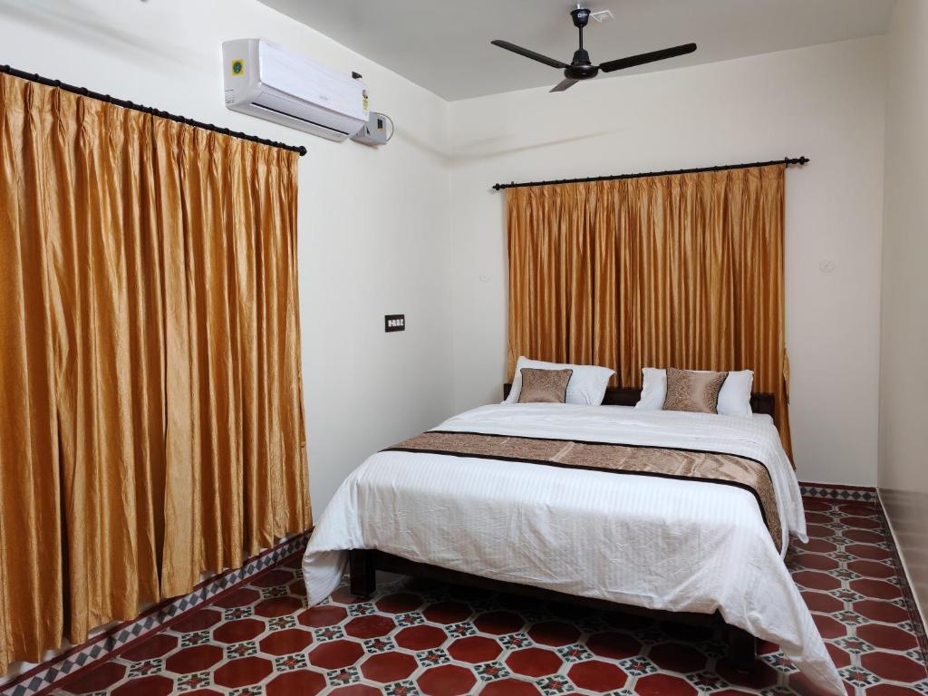 a bedroom with a large bed and curtains at The Sparrow House 2BHK Ground Floor in Kumbakonam