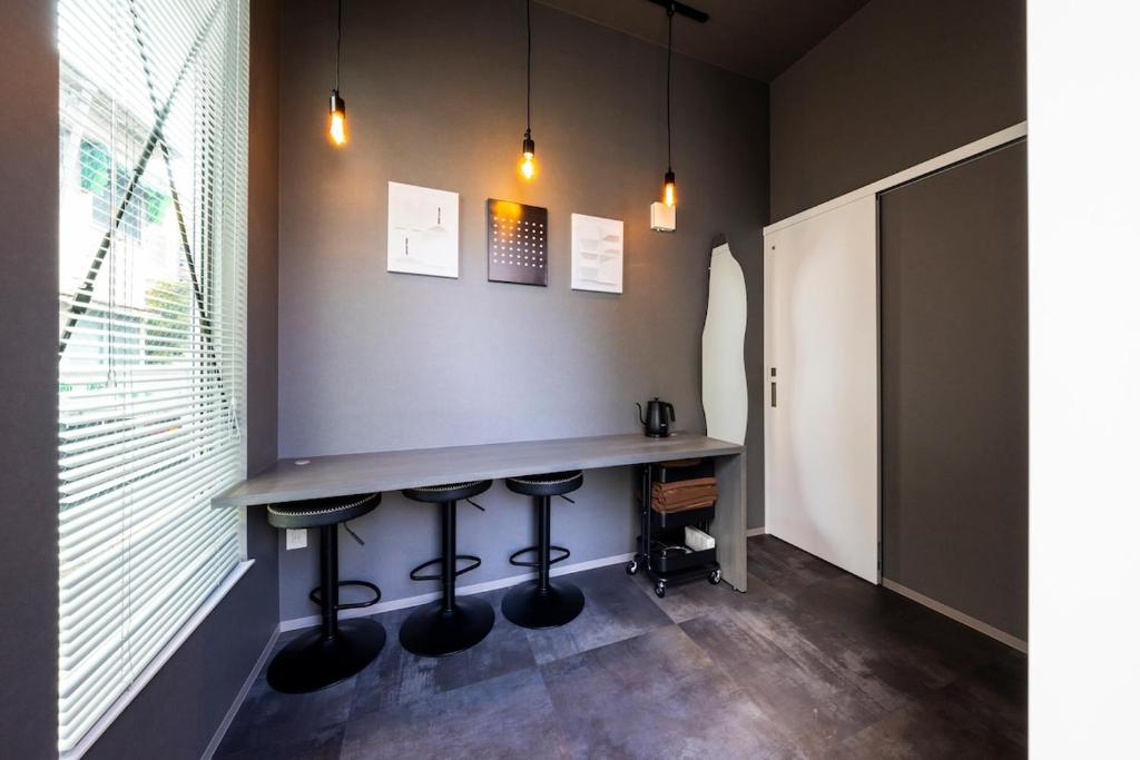 a bar in the corner of a room with stools at Amp Flat 清川 in Sumiyoshi