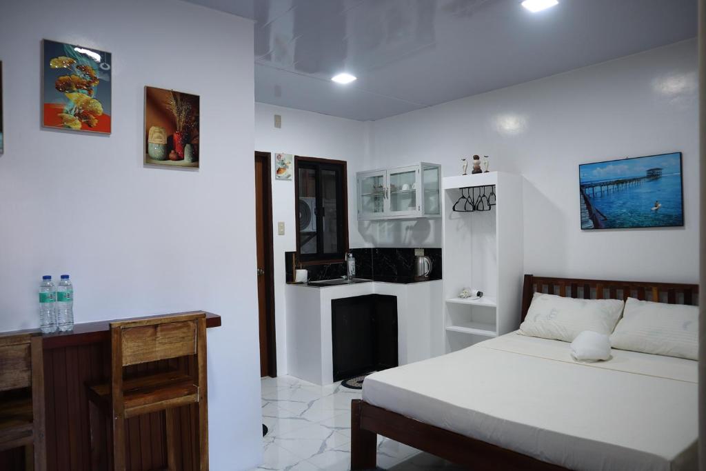 una camera bianca con letto e camino di Jmt Star's Inn a General Luna