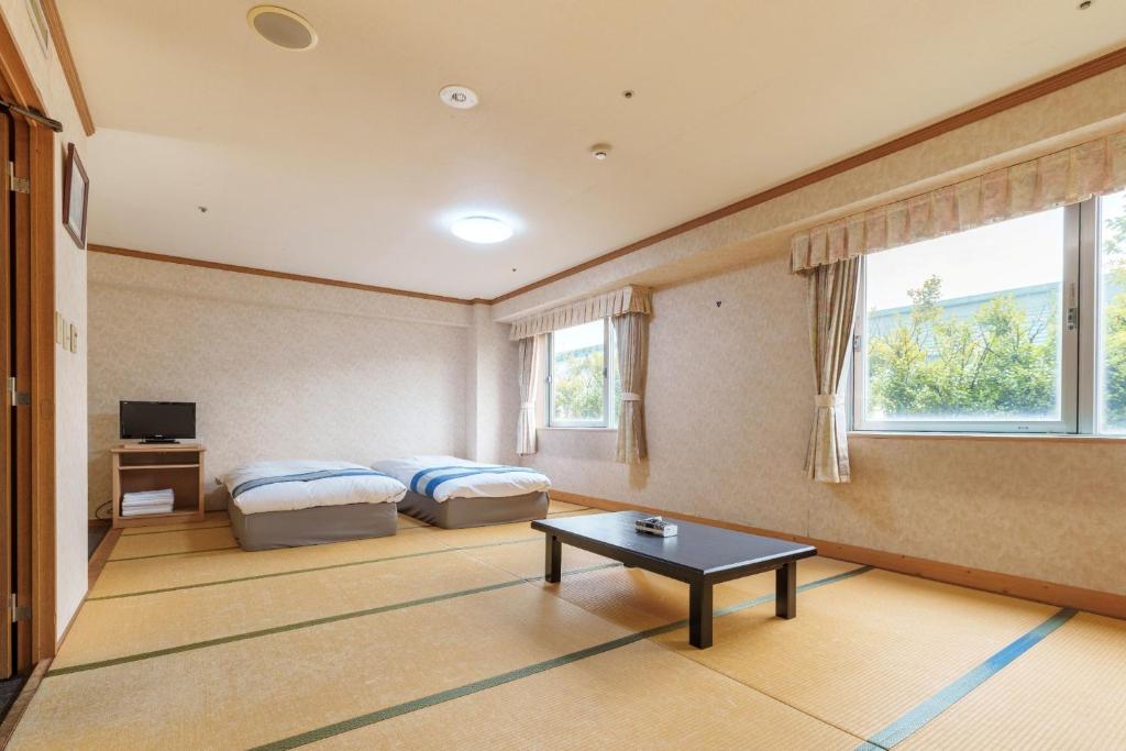 a room with two beds and a table in it at Hotel KOYO Bekkan - Vacation STAY 37061v in Hashima
