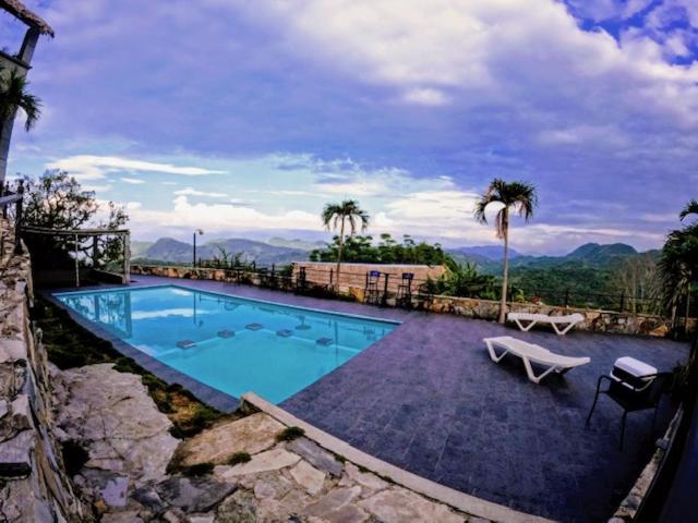 una gran piscina con banco y palmeras en Hotel Monte Ixk'al Xilitla, en Xilitla