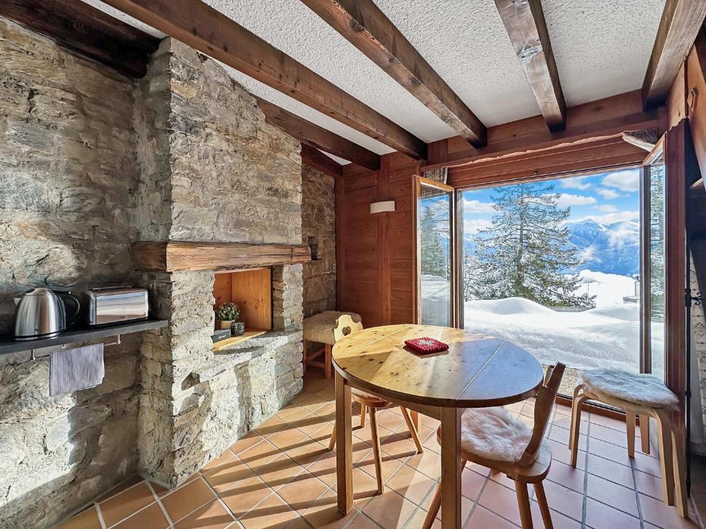 een keuken met een tafel en een groot raam bij PO Petite Ourses Suite - Anzere Slopeside - Swiss Alp in Anzère