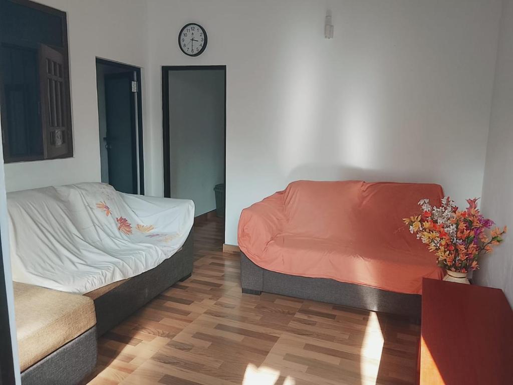 a bedroom with a bed and a clock on the wall at House for rent in Daluwekotuwa