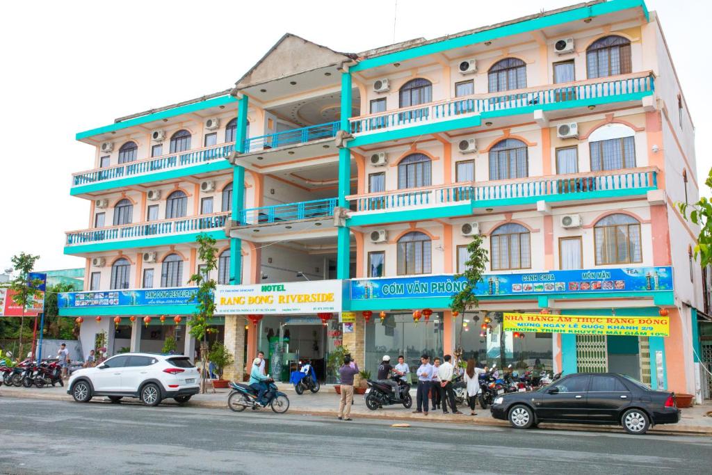 um grande edifício com varandas azuis numa rua da cidade em Rang Dong Hotel em Mỹ Tho