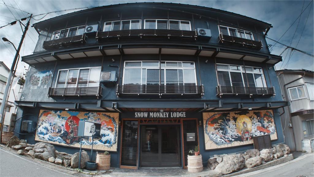 a blue building with posters on the side of it at Snow Monkey Lodge in Yamanouchi
