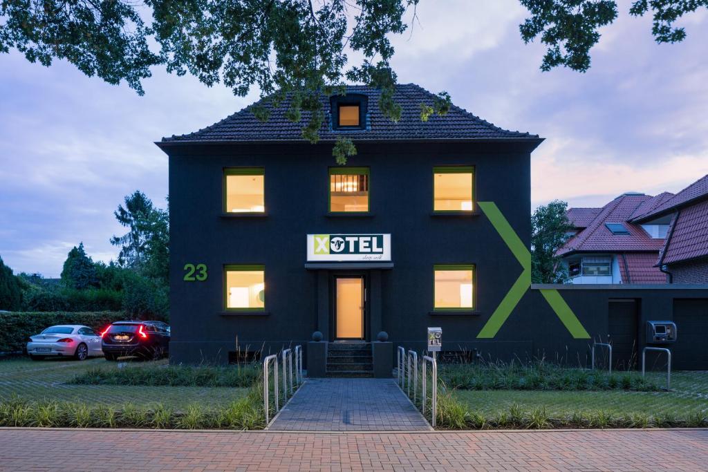 a black house with a sign on it at Xotel in Xanten