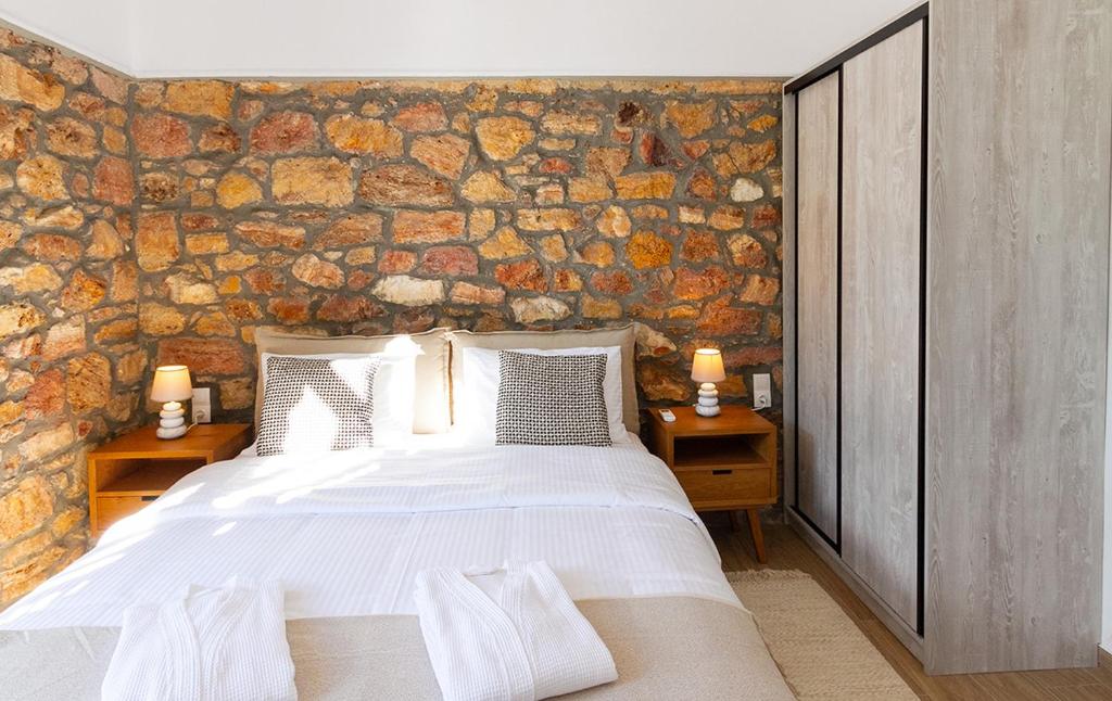 ein Schlafzimmer mit einer Steinmauer und einem Bett in der Unterkunft Stone House Edipsos in Loutra Edipsou