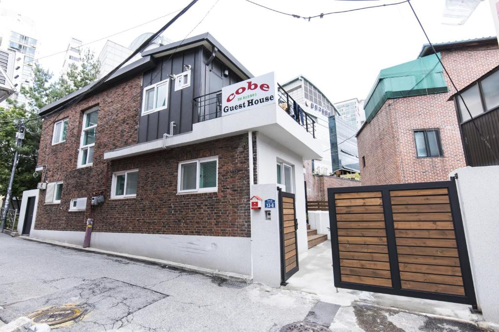 a building with a garage on a street at Cobe Guesthouse Dongdaemun in Seoul