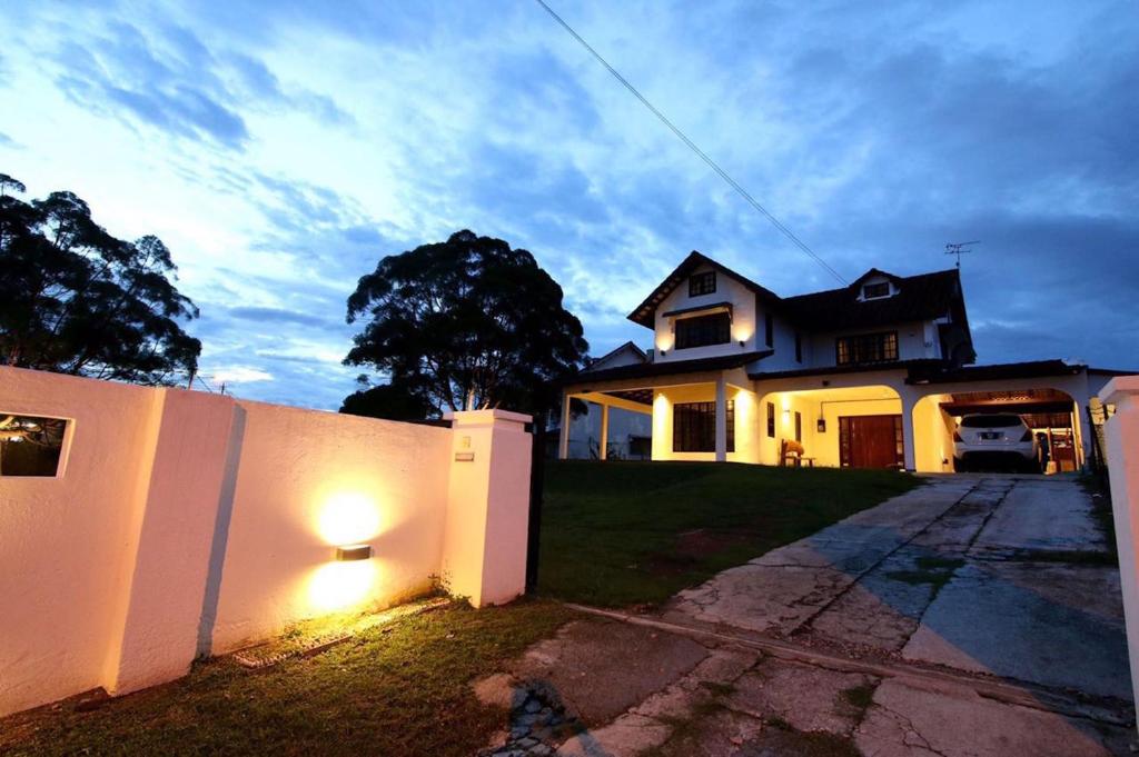 une maison avec un mur blanc et une clôture dans l'établissement The Pines Cottage, à Malacca