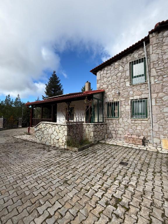 una casa in pietra con un vialetto di mattoni davanti di Santa House ad Aráchova