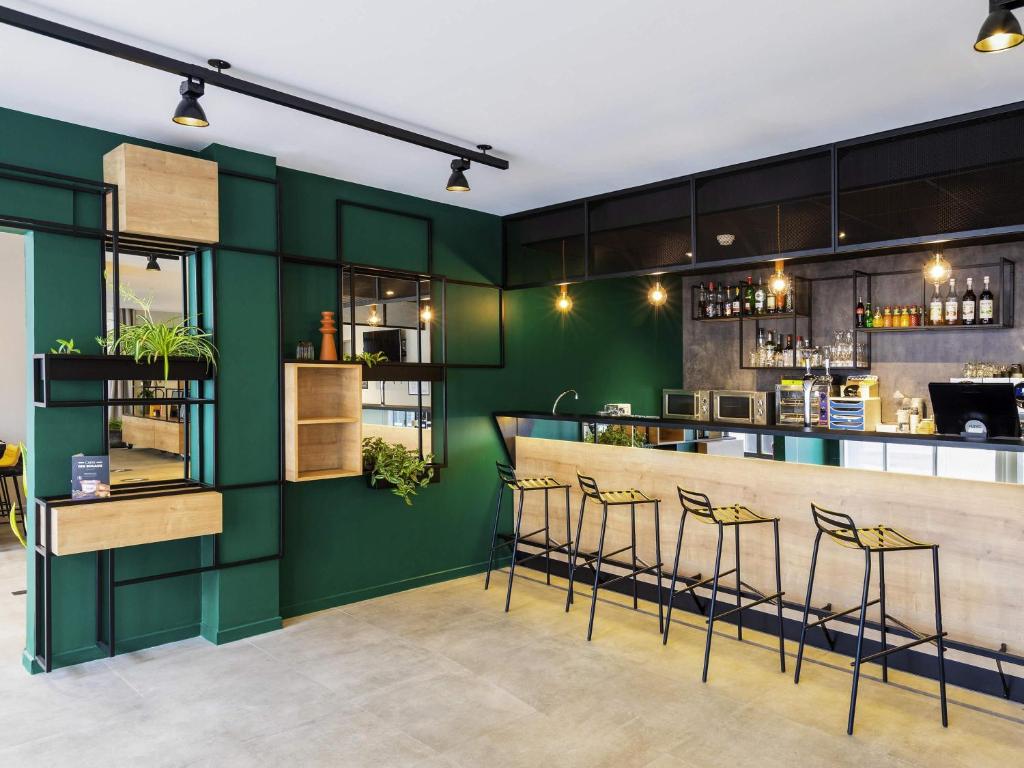 eine grüne Bar in einem Restaurant mit Barhockern in der Unterkunft Ibis Pau Centre in Pau