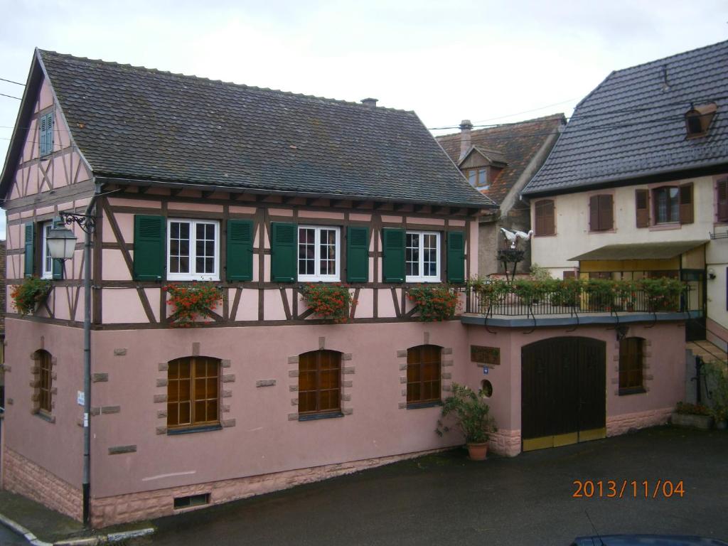 ディーフェンタールにあるGite Au Nid De Cigognesの緑の襖とピンクの古い家