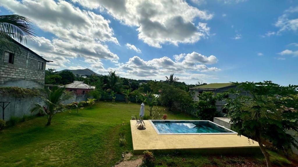 a backyard with a swimming pool in the grass at VILLA RAVOLA - Ambondrona in Nosy Be
