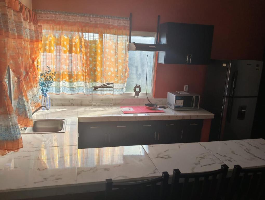 a kitchen with a counter and a sink and a window at Shalom in Ciudad Valles