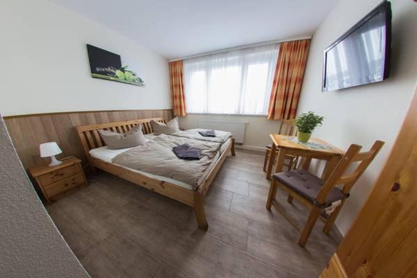 - une chambre avec un lit, une table et une chaise dans l'établissement Hollis Rast, à Sangerhausen
